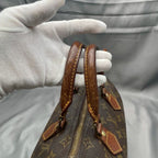Close-up of the Louis Vuitton Speedy 30's leather handles, showing stitching and patina